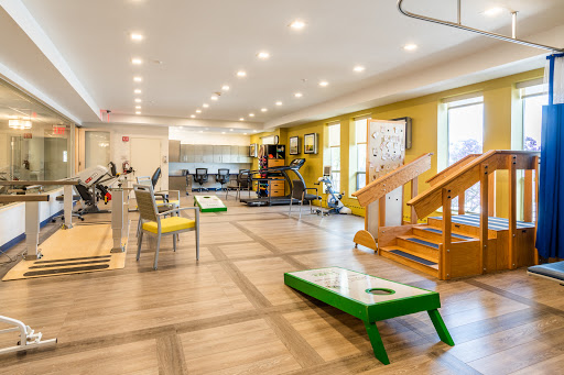 A well-lit and spacious fitness center equipped with various exercise machines and recreational activities.
