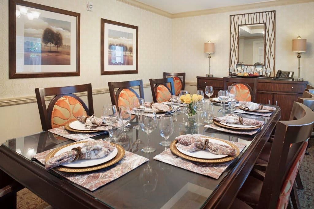 A beautifully set dining table in a formal dining room, featuring elegant place settings and decor.