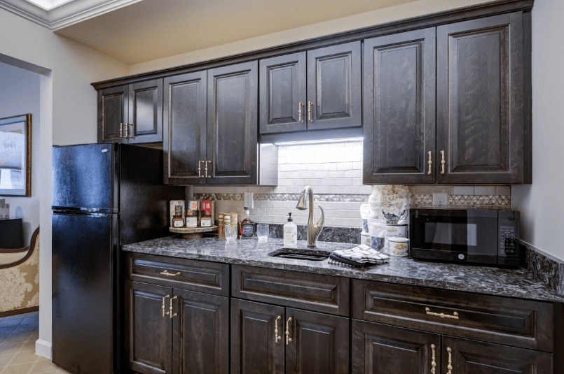 Modern kitchen with dark wood cabinets and sleek countertop appliances.