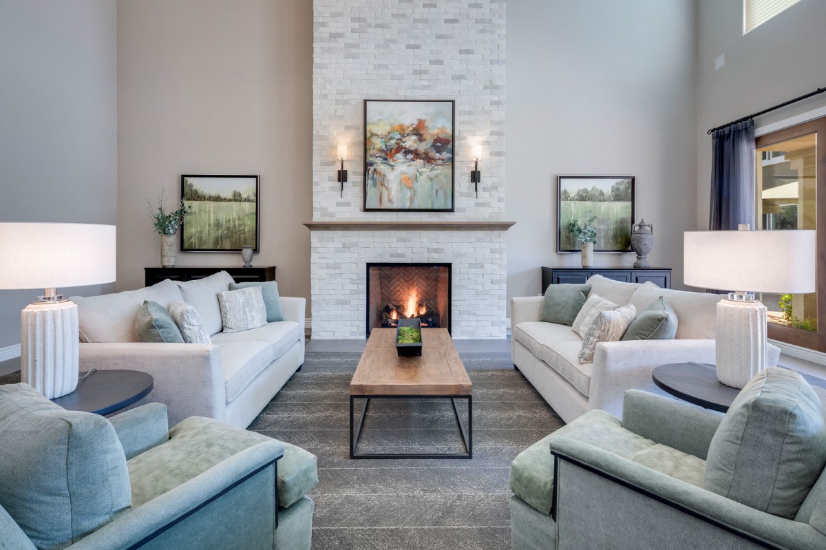 A modern living room with a central fireplace, comfortable sofas, and elegant artwork.