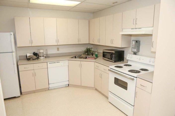 A modern kitchen with white cabinets and appliances.