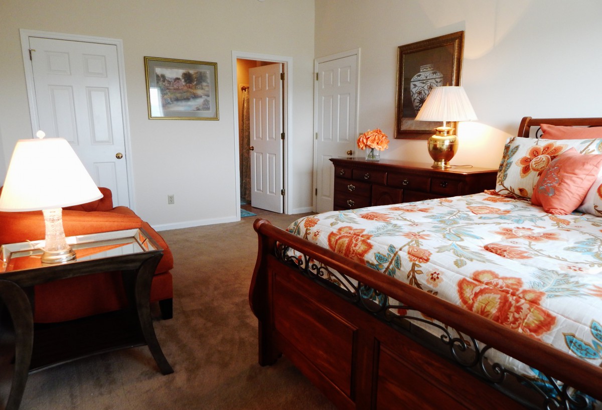 A cozy bedroom with a decorated bed and warm lighting.