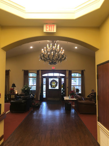 A warm and inviting lobby featuring a stylish chandelier and comfortable seating.