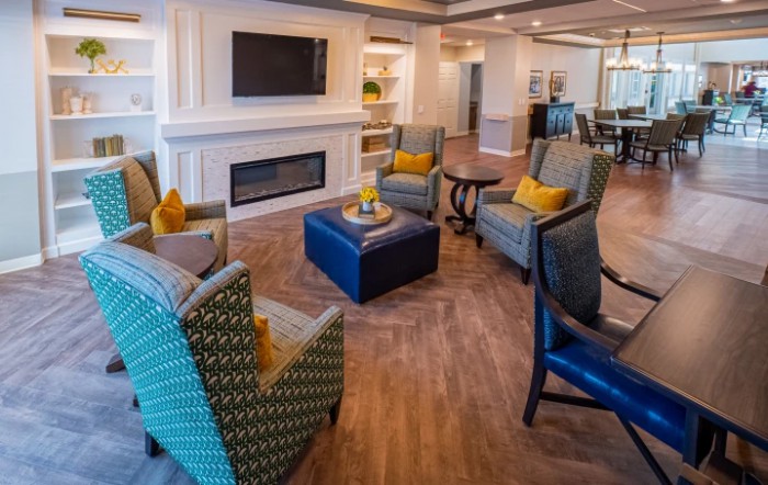 A cozy and modern living room with comfortable seating around a fireplace and TV.