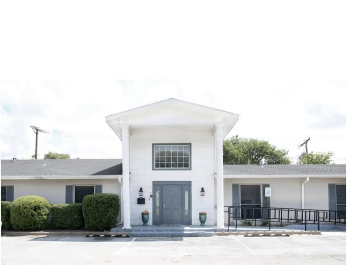A white building with large columns and a central entrance.