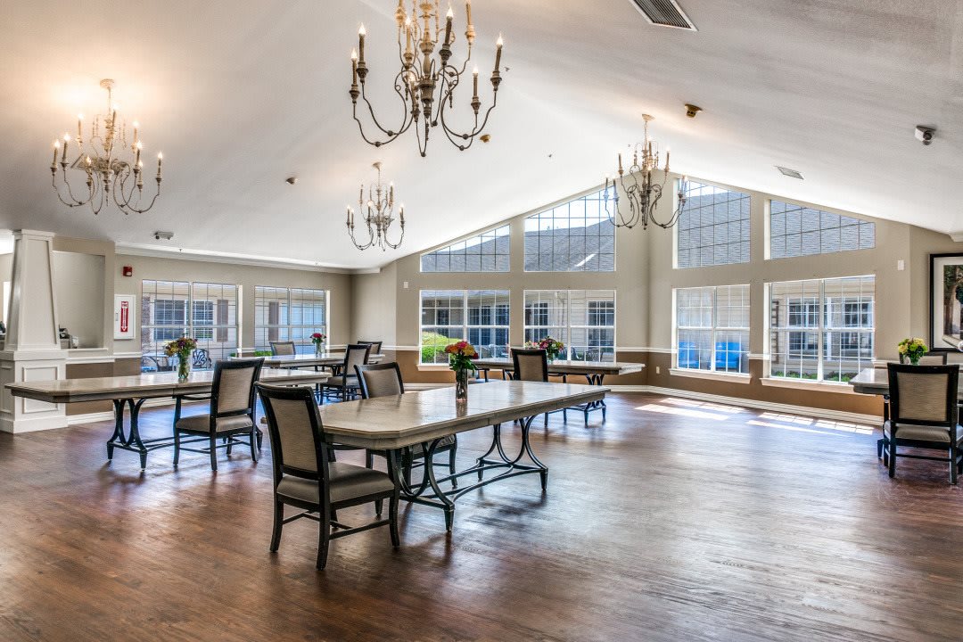 A spacious dining area with large windows and elegant chandeliers.