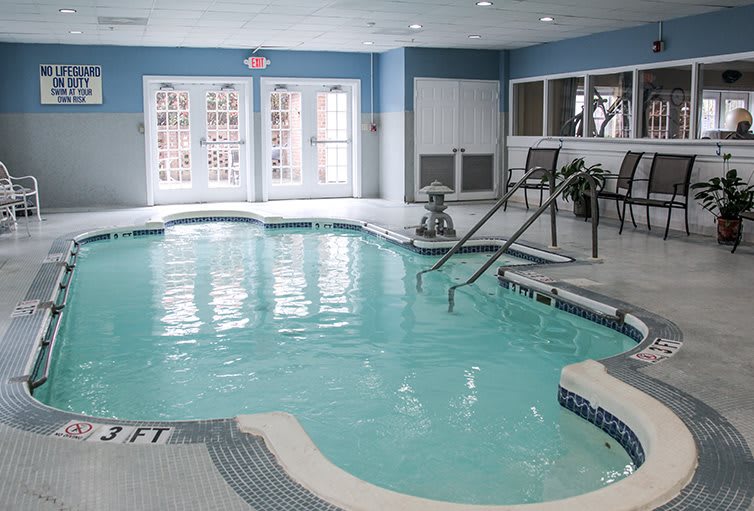 An inviting indoor swimming pool with seating and easy access.