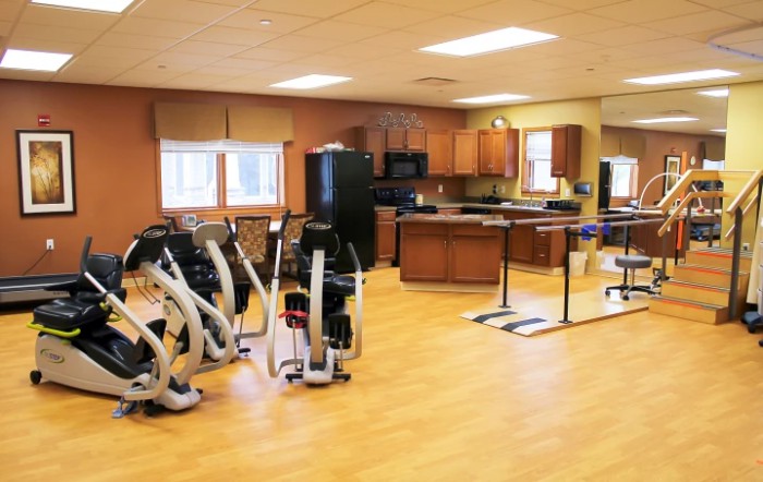 A rehabilitation room equipped with exercise machines and therapy areas.