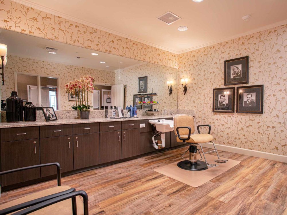 A cozy and well-decorated salon interior with chairs, mirrors, and wooden flooring.