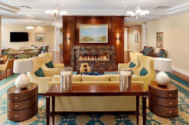 A luxurious living room interior with a central fireplace and elegant seating area.