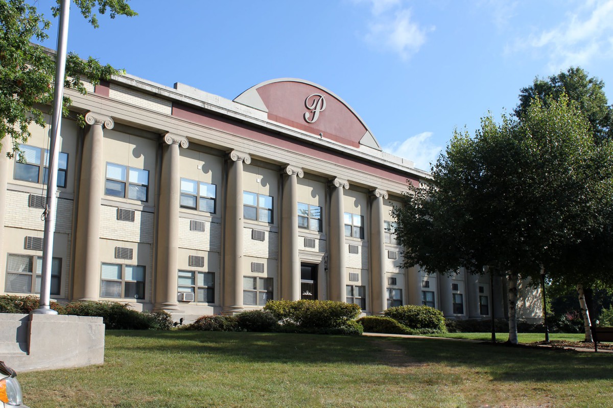 A classic school building with columns and a landscaped front yard.