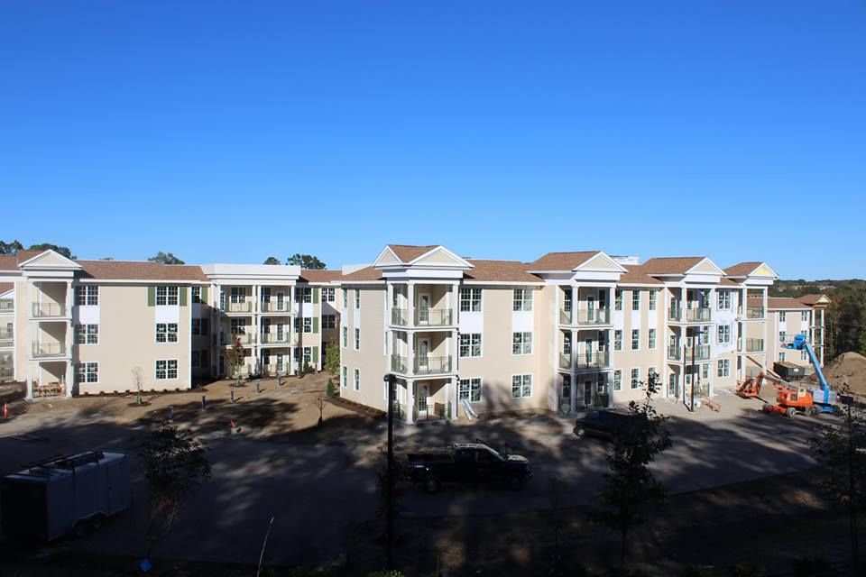 A view of a multi-story apartment building under a clear blue sky.