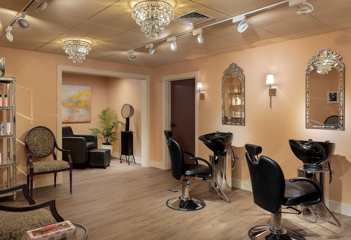 A stylish hair salon with modern decor, featuring elegant chandeliers and comfortable styling chairs.