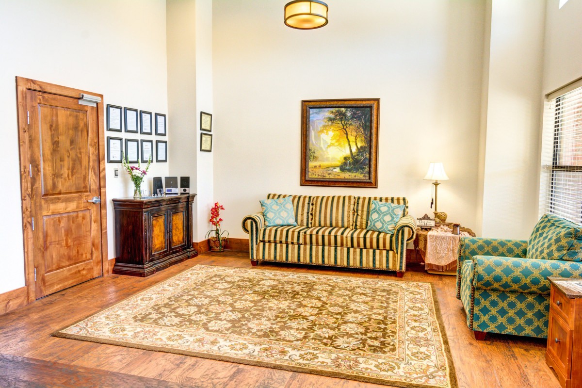 A cozy living room featuring a striped couch, decorative rug, and framed artwork, all accentuated by warm lighting.