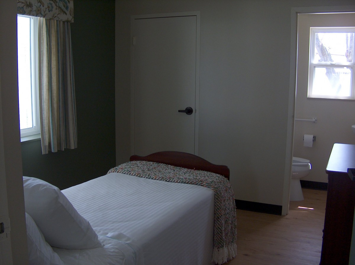 A minimalist bedroom with a single bed and simple decor.