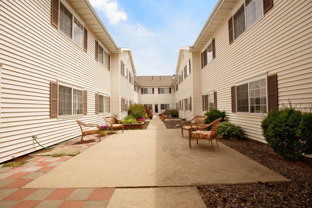 A peaceful residential courtyard featuring benches and landscaped pathways.