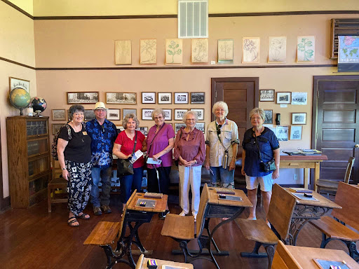 A group of visitors exploring a historical classroom museum.