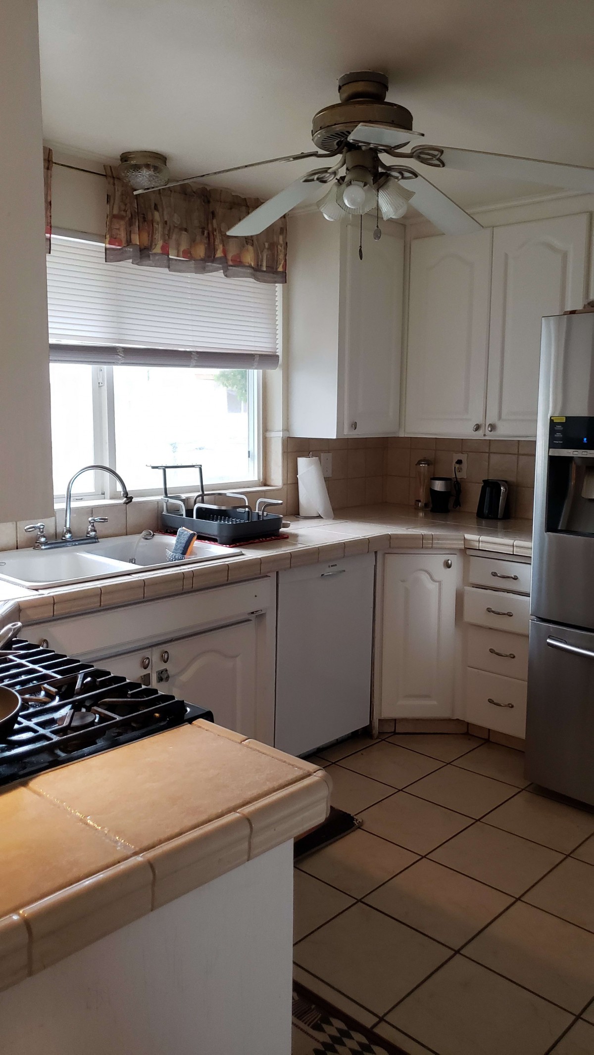 A modern kitchen with white cabinets and stainless steel appliances.