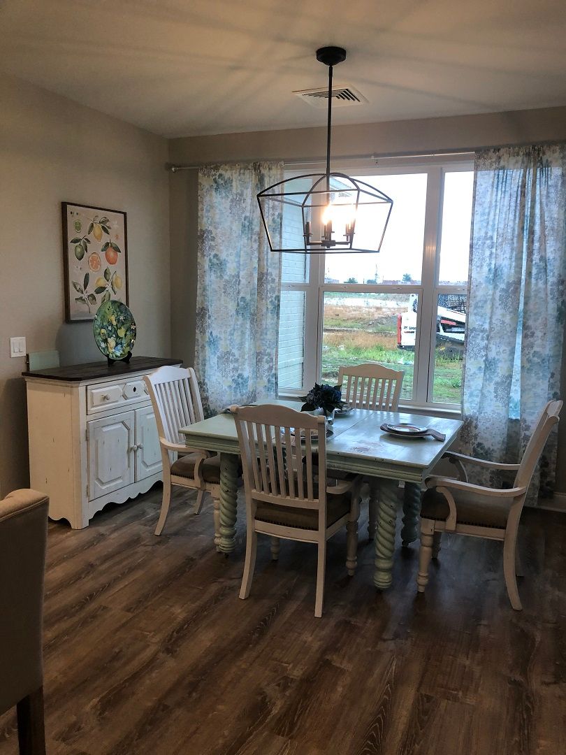 A cozy dining area with a table, chairs, and a large window offering natural light.