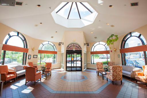 A bright and welcoming lobby with comfortable seating and a skylight, designed for relaxation.