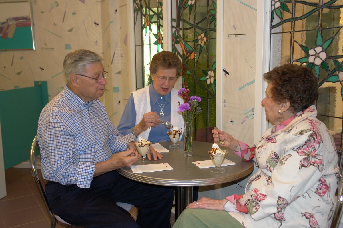 A group of seniors enjoying ice cream together indoors.