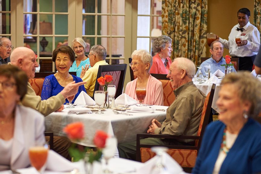 A group of seniors enjoying a meal together at a dining table.