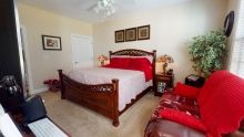 A cozy bedroom with a wooden bed frame and vibrant red accents.
