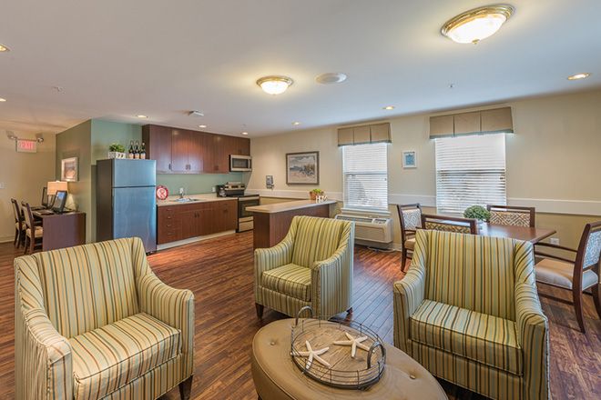 A modern apartment living area with a cozy seating arrangement and an open kitchen layout.