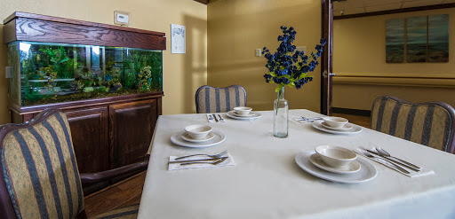 A beautifully arranged dining table with elegant tableware and a floral centerpiece.