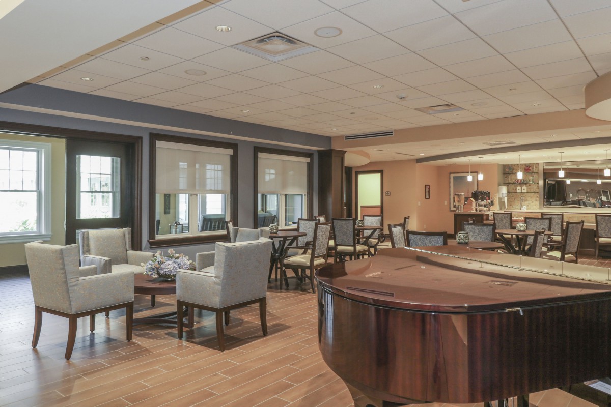 A cozy lounge area with a grand piano and multiple seating arrangements.