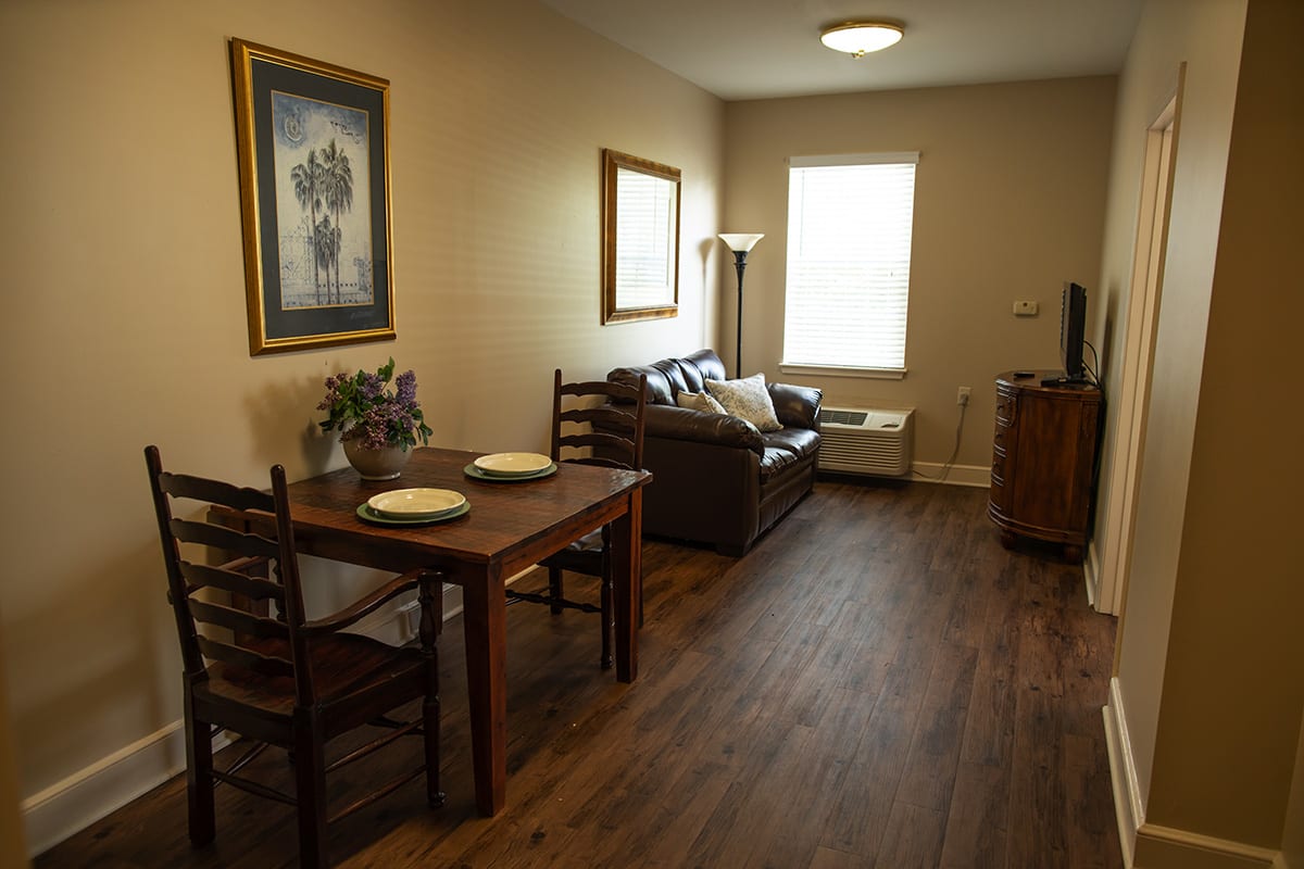 A cozy living room with a dining area and a sofa facing a television.