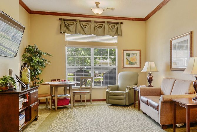 A cozy living room with comfortable furniture and a large window.