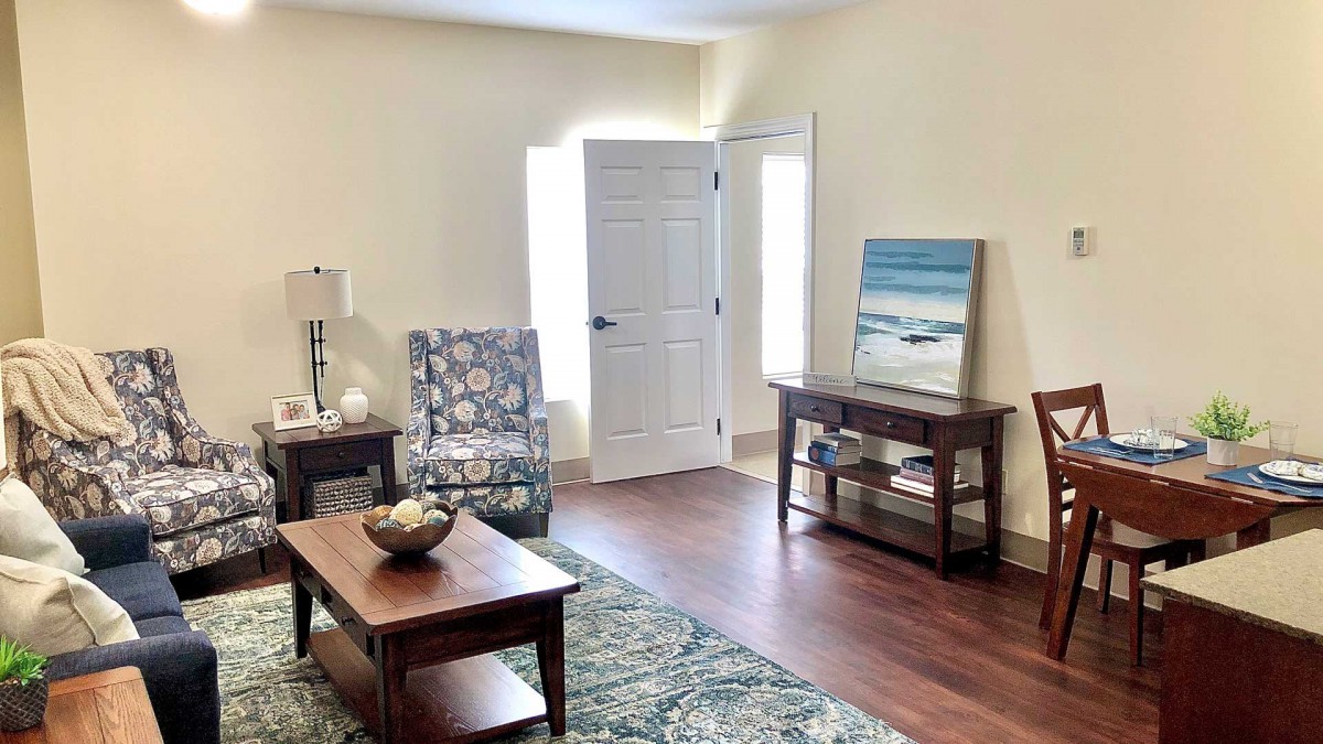A cozy living room with modern furniture and a beach-themed artwork.