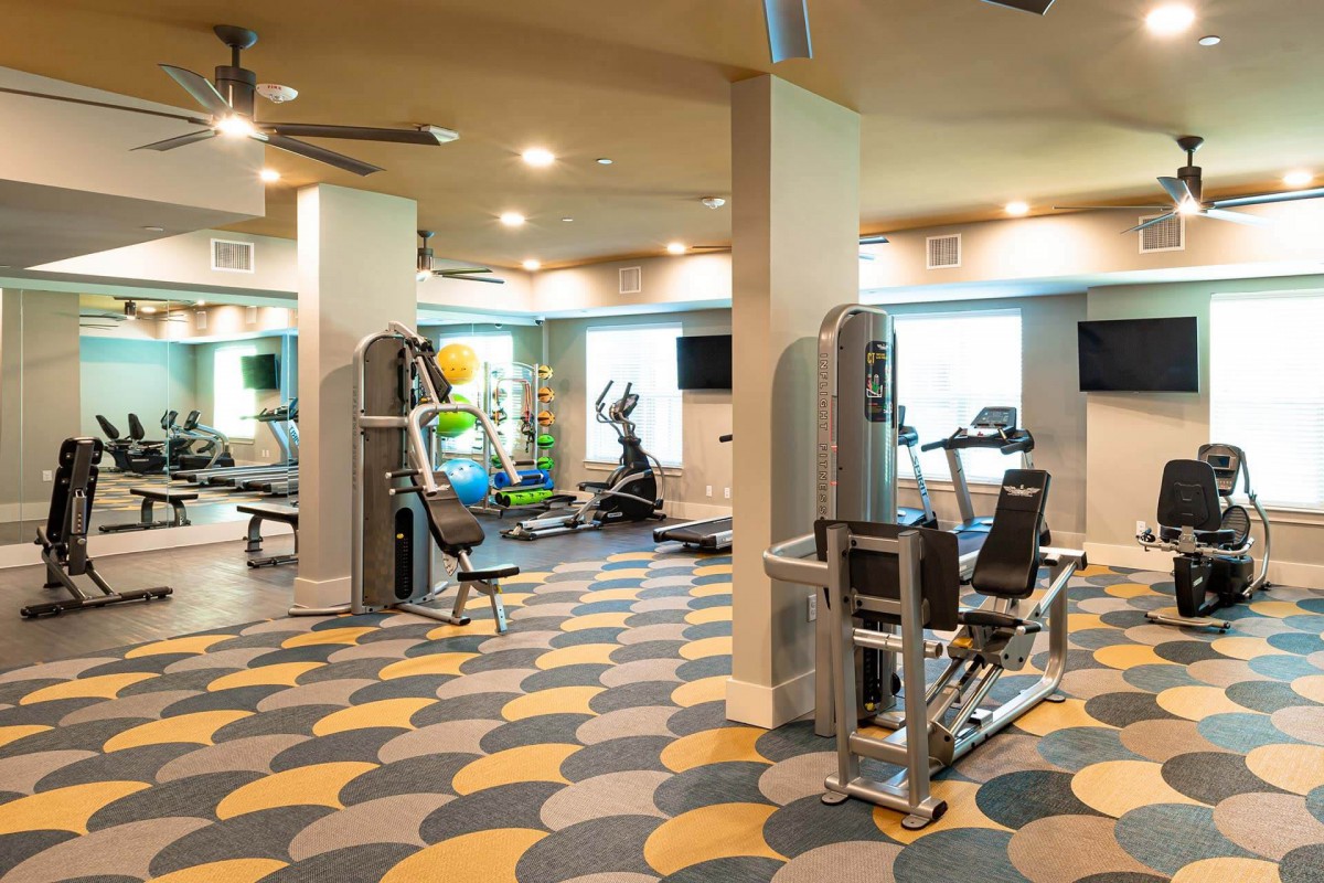 Bright and modern gym with various exercise machines.