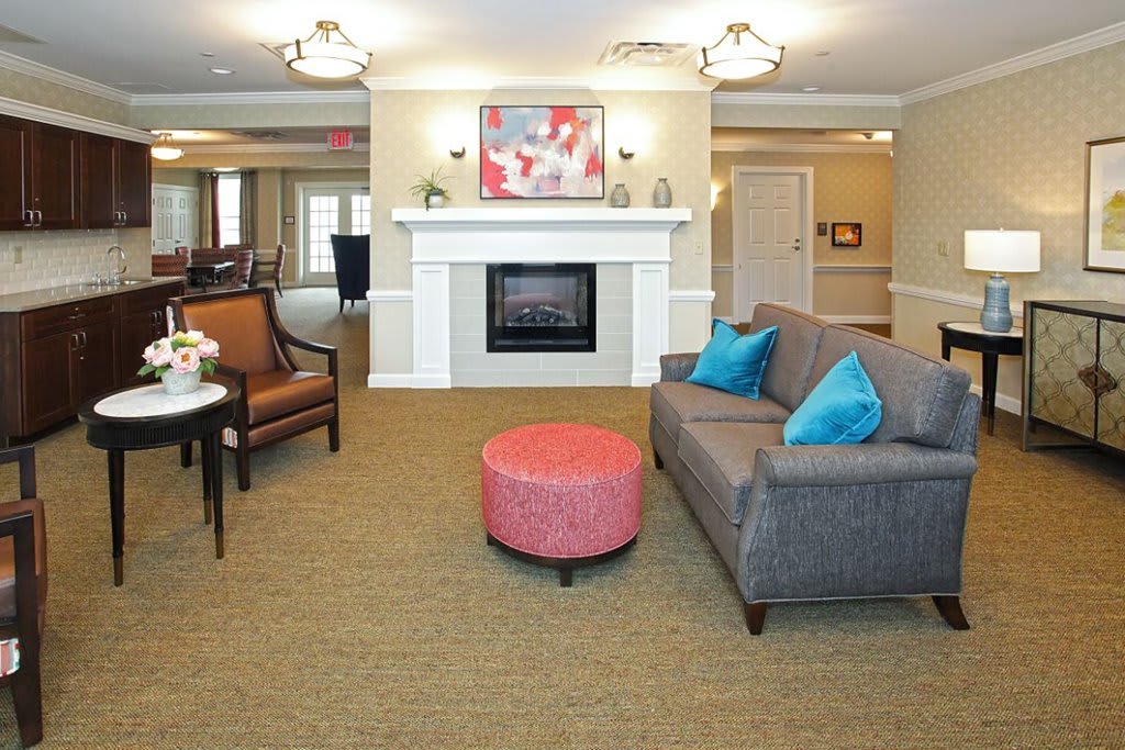 A modern living room featuring a cozy fireplace, colorful cushions on the sofa, and contemporary artwork.
