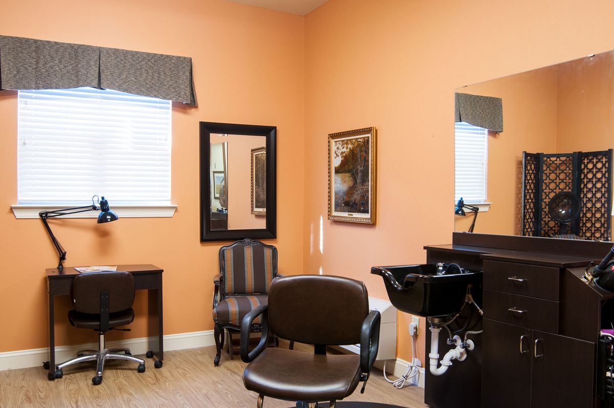 An interior view of a hair salon with chairs, mirrors, and a sink.