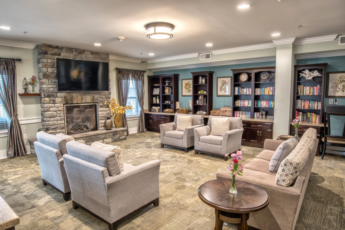 A cozy and well-designed living room with comfortable seating, a fireplace, and bookshelves.