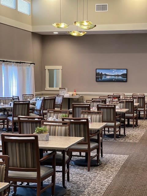 An empty dining area with neatly arranged tables and chairs, decorated in a modern style.