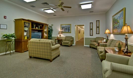 A cozy living room with comfortable seating and a television entertainment center.