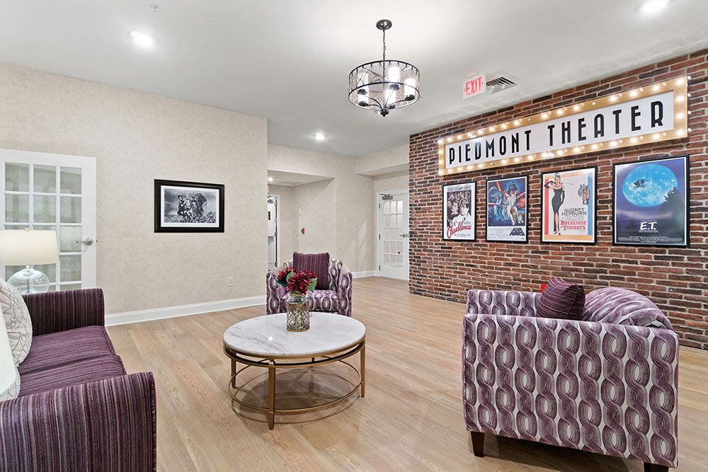 A modern lobby with plush seating, artwork, and a chandelier.