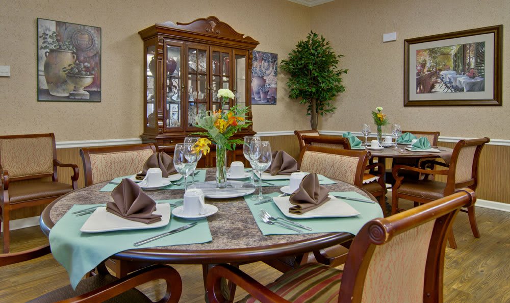 An elegantly set dining table with fine china and glassware in a well-decorated dining room.