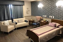A modern hospital room with comfortable seating and a well-designed layout.