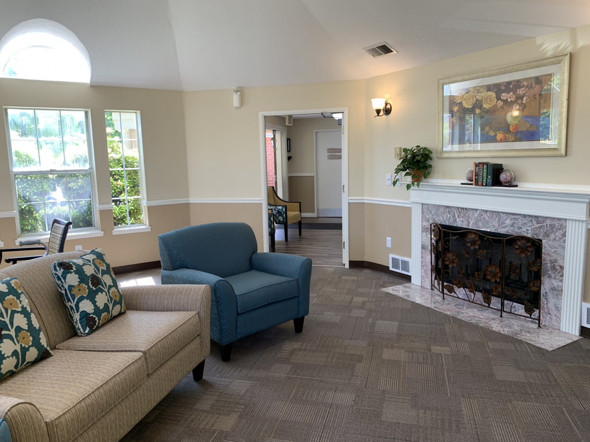 A cozy living room featuring a sofa, armchair, and a fireplace.