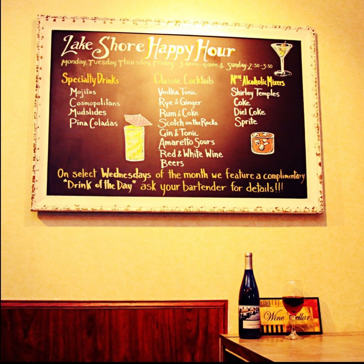A restaurant chalkboard highlighting happy hour specials and cocktails.