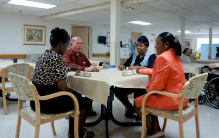 A group of people having a meeting around a table in an indoor setting.