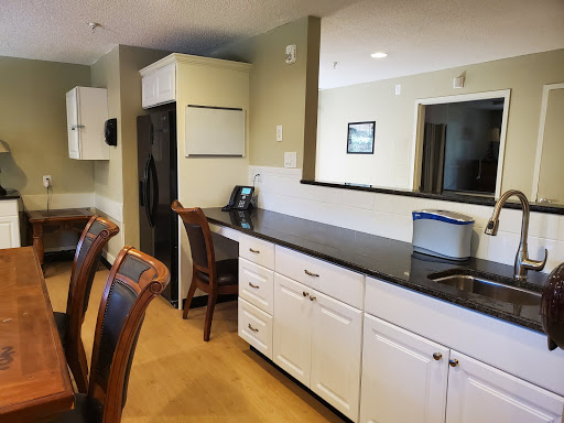 A spacious and modern kitchen featuring sleek black countertops and bright cabinetry.