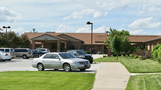 A view of a parking lot in front of a building on a sunny day.