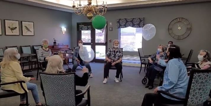 Seniors engaging in a group activity with balloons in a community center.