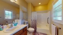 A modern bathroom with a sink, toilet, and bathtub featuring a decorative shower curtain.