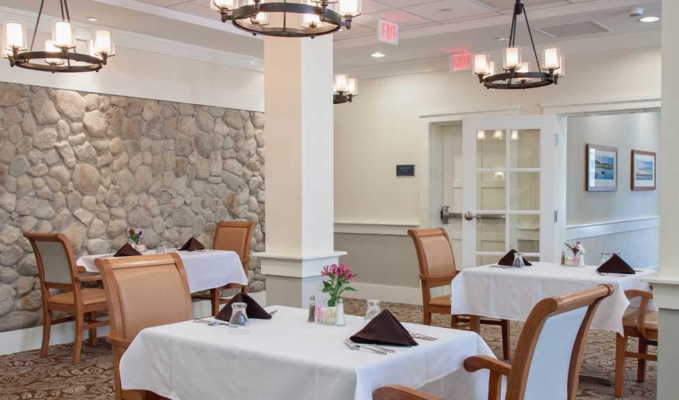 An elegant dining room with neatly set tables and comfortable chairs.